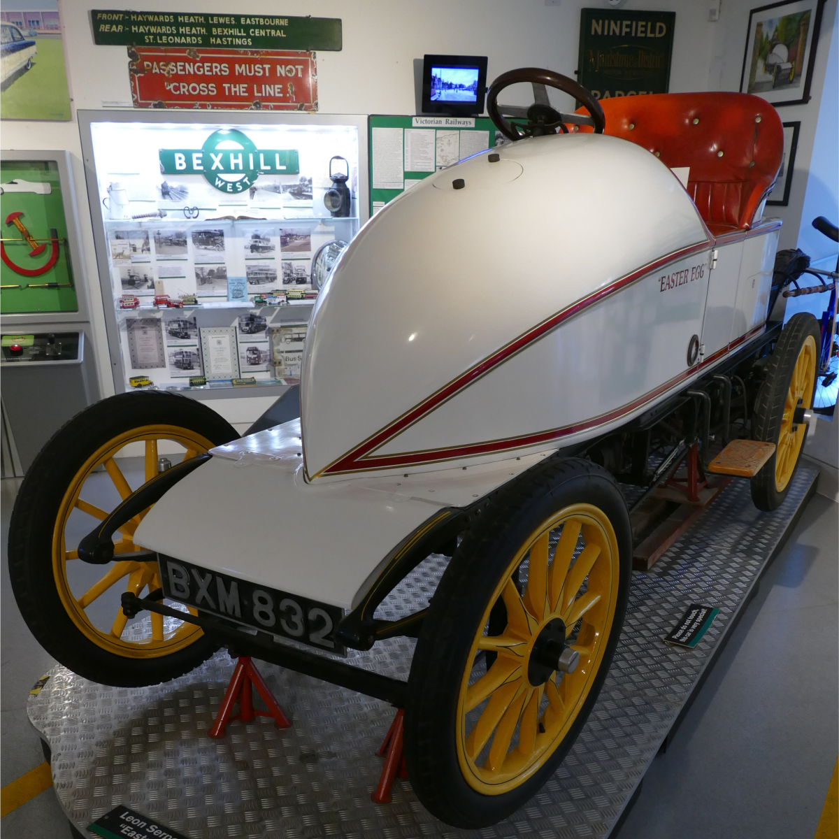 Early electric racing car “Volta” from the Easter Egg exhibition at Bexhill Museum, displayed indoors with historic transport displays behind